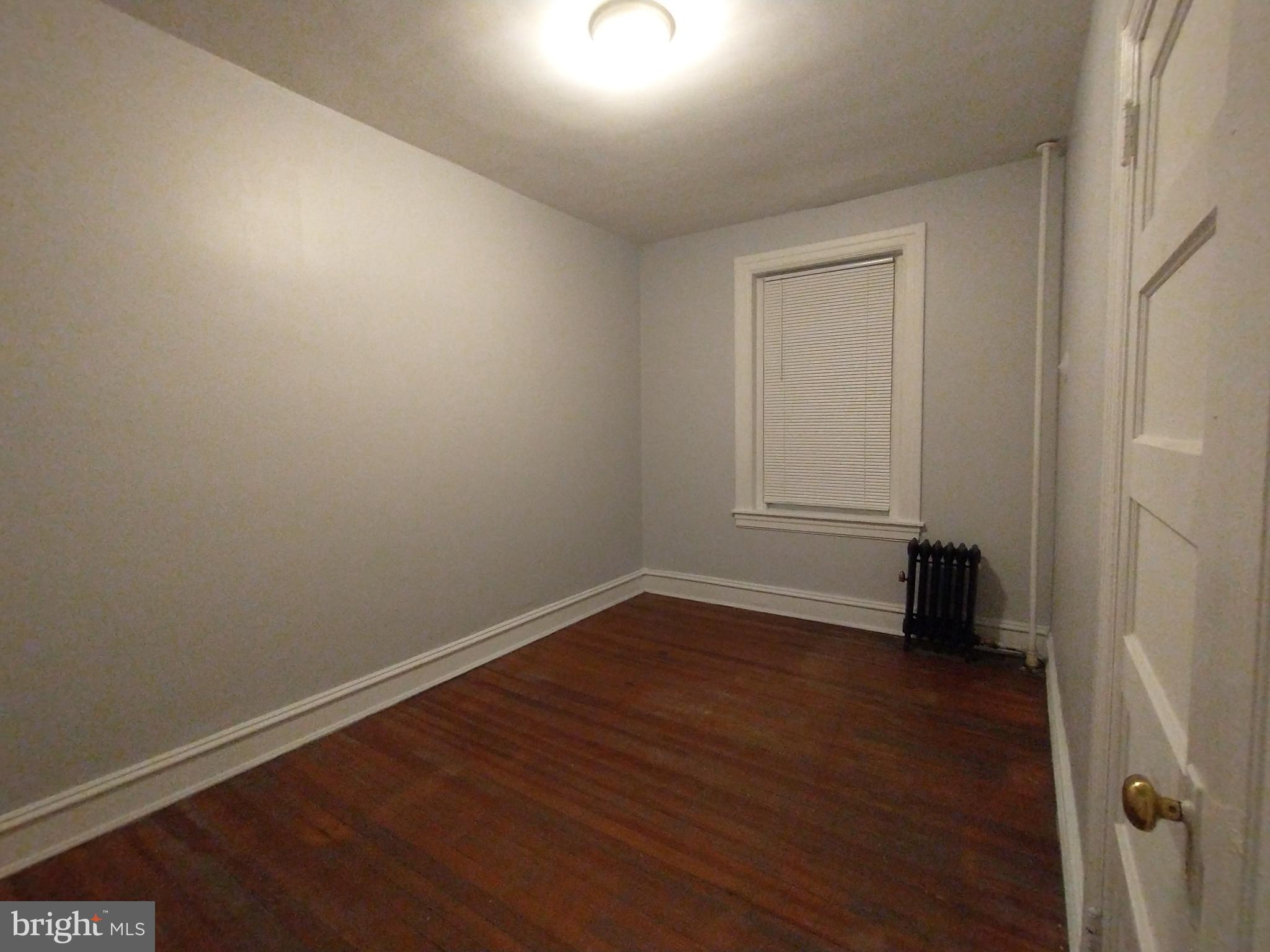 307 Dolphin Street, Unit 3C Baltimore, MD 21201 - Photo 11 of 14 a view of an empty room with wooden floor and a window