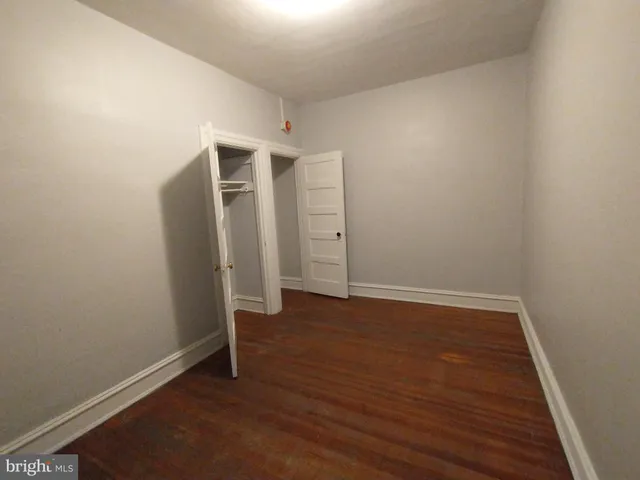 an empty room with wooden floor and closet