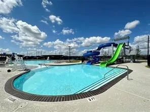 a view of a swimming pool with a yard and plants