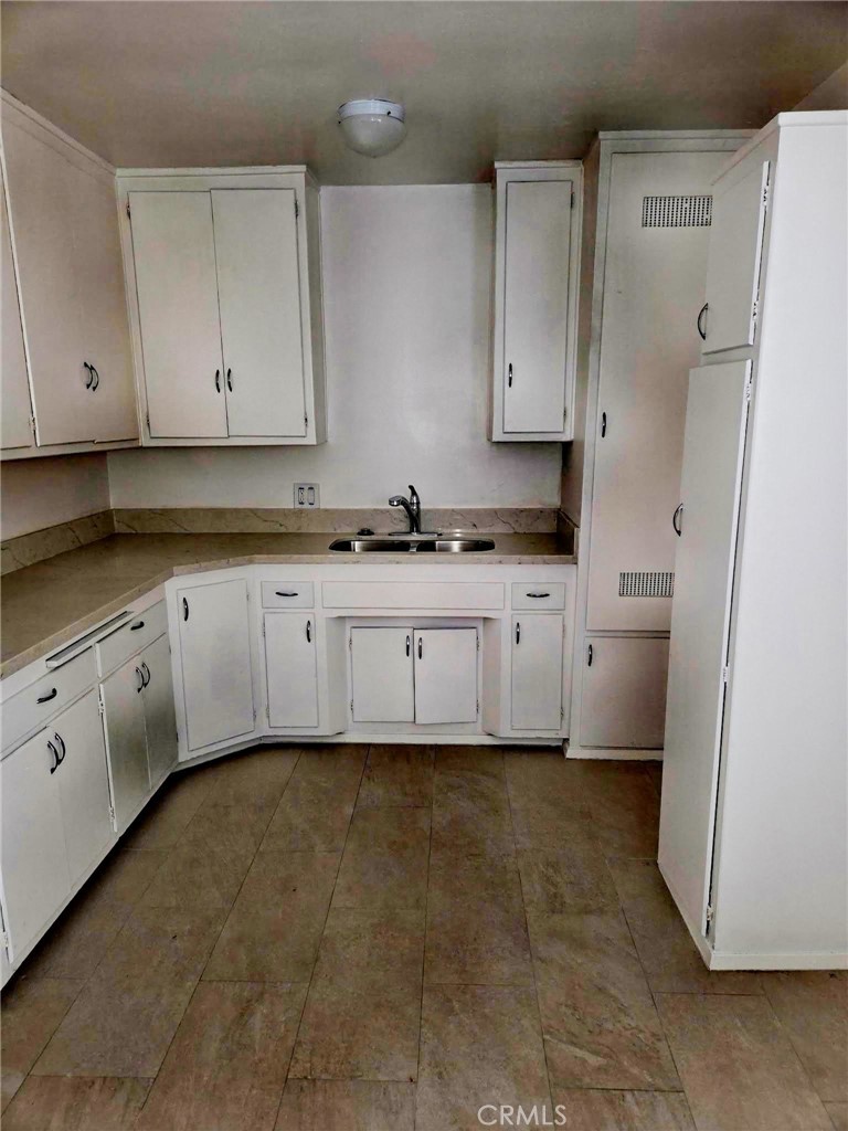 410 West Magnolia Street, Unit 2 Compton, CA 90220 - Photo 2 of 4 a kitchen with granite countertop a sink a stove a refrigerator and cabinets