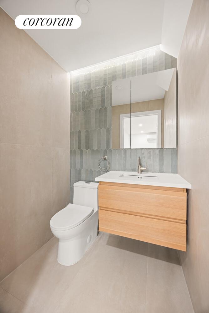 48 Stanhope Street, Unit 1F Brooklyn, NY 11221 - Photo 9 of 11 a bathroom with a sink toilet and mirror