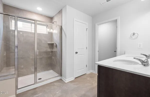 a bathroom with a shower sink and mirror