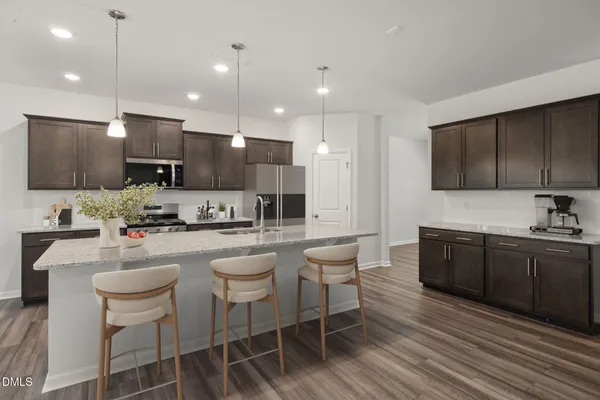 a kitchen with kitchen island granite countertop wooden cabinets and stainless steel appliances