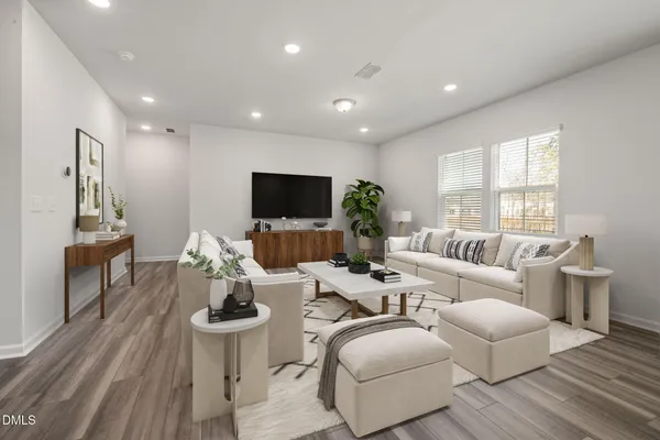 a living room with furniture a flat screen tv and a large window