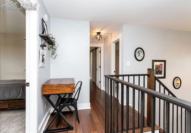 a view of a hallway to room with furniture and wooden floor