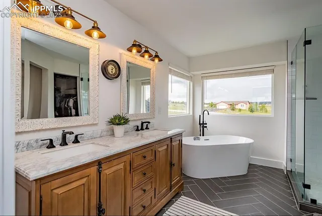 a bathroom with a double vanity sink mirror and bathtub