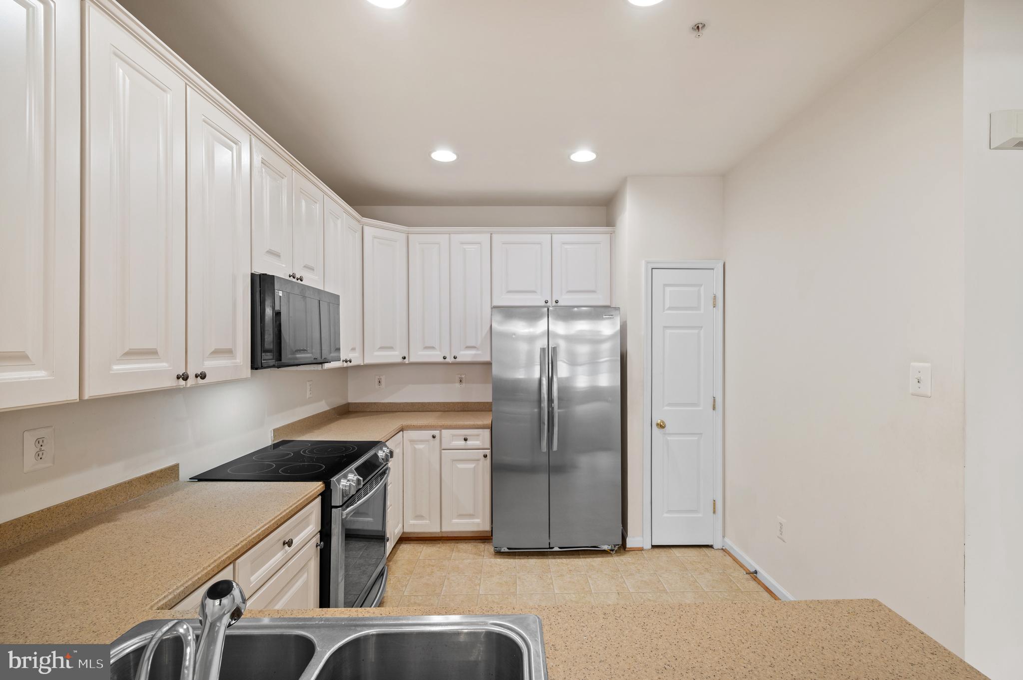 7122 Silverleaf Oak Road, Unit 227 Elkridge, MD 21075 - Photo 22 of 55 a kitchen with a refrigerator a stove and a sink with wooden floor