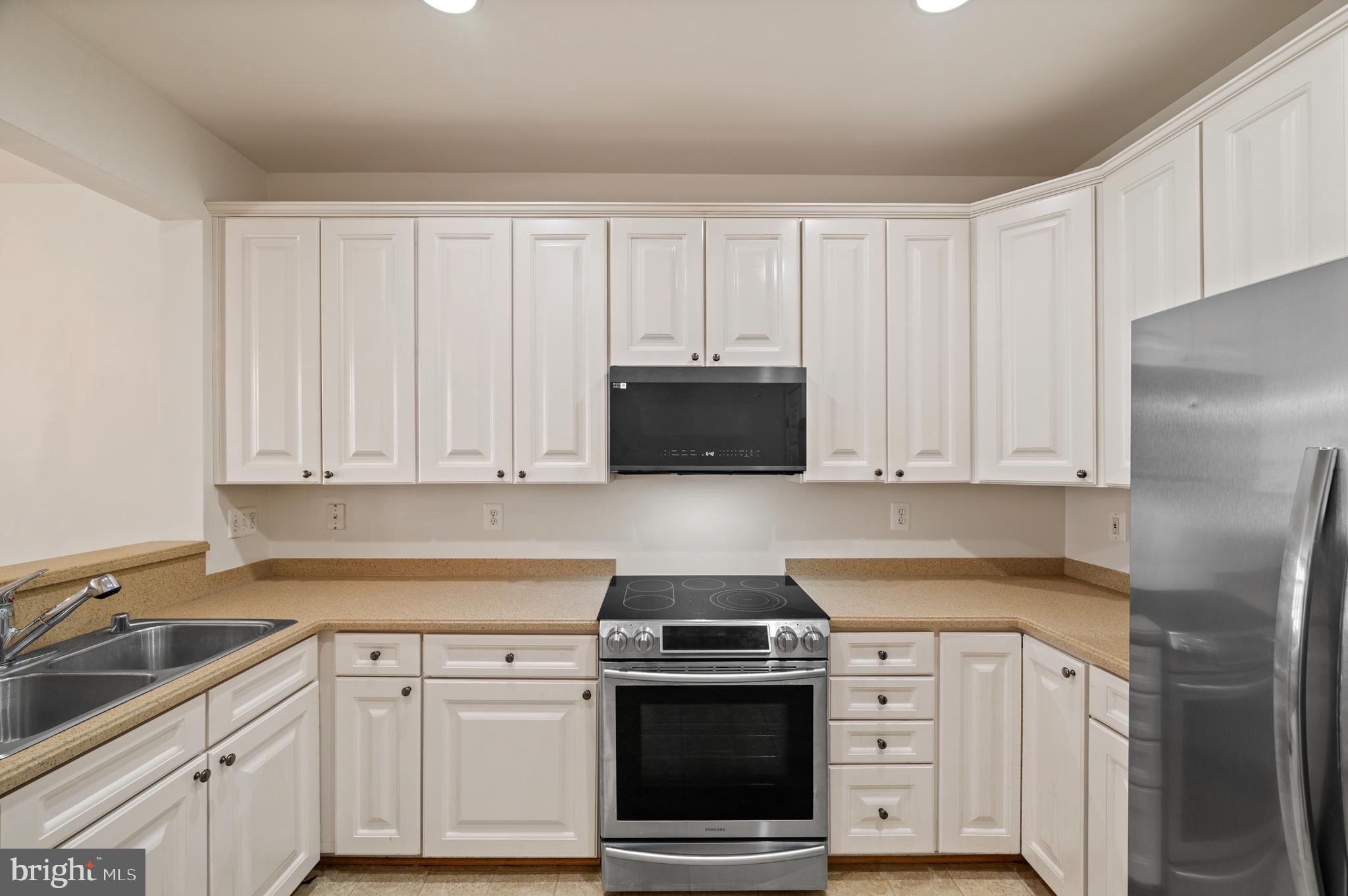 7122 Silverleaf Oak Road, Unit 227 Elkridge, MD 21075 - Photo 23 of 55 a kitchen with granite countertop white cabinets and stainless steel appliances