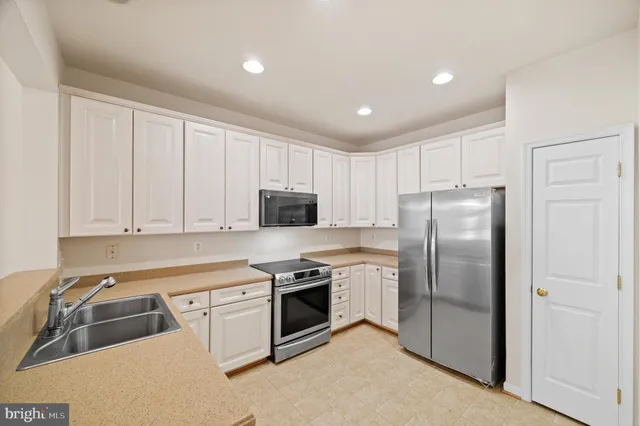 a kitchen with a refrigerator sink and cabinets