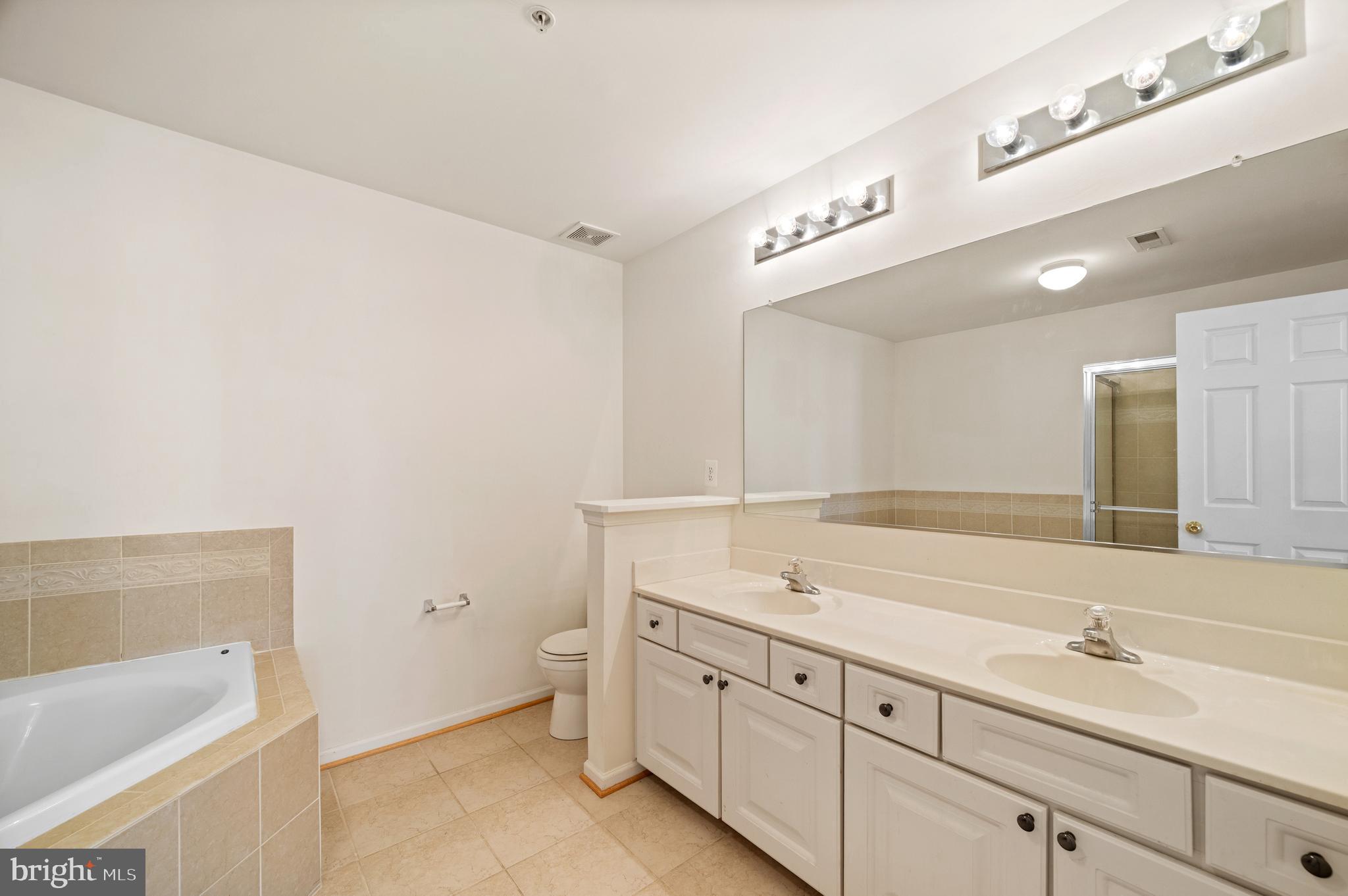 7122 Silverleaf Oak Road, Unit 227 Elkridge, MD 21075 - Photo 6 of 55 a spacious bathroom with a granite countertop sink and a bathtub