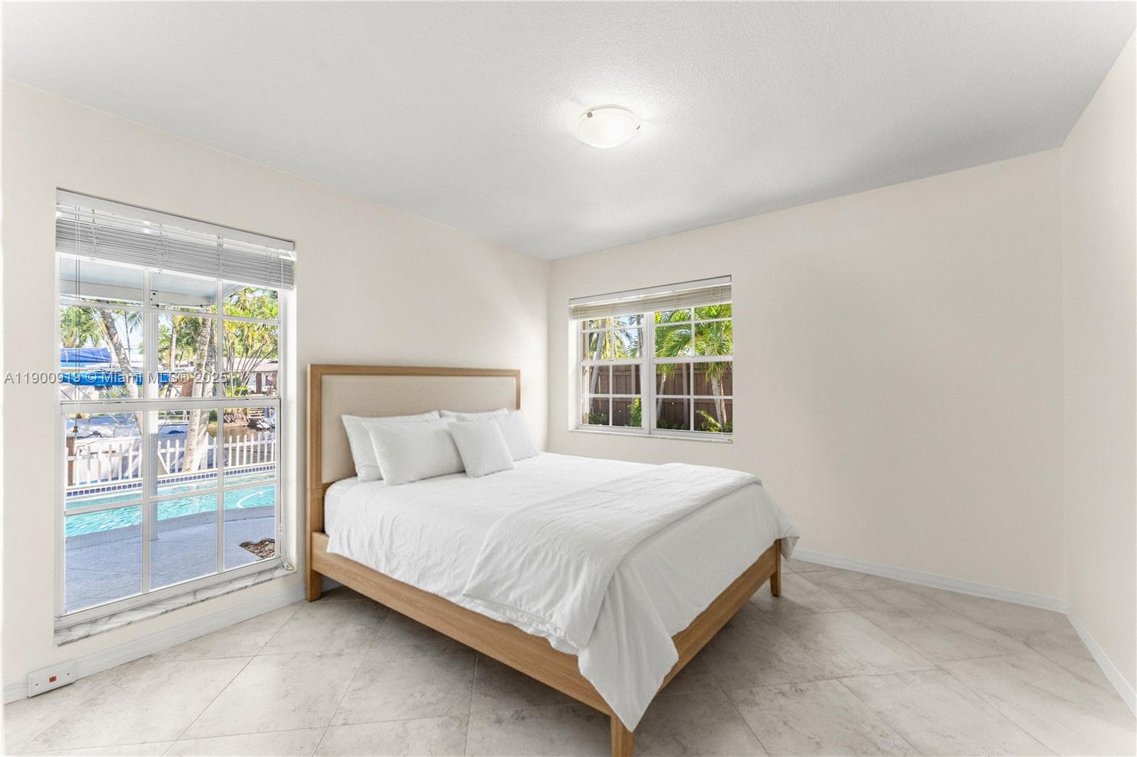 1625 Southwest 5th Court Fort Lauderdale, FL 33312 - Photo 15 of 22 a bedroom with a bed lamp and a large window