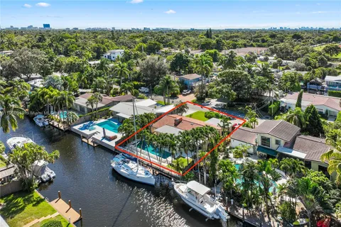 an aerial view of a house with a yard and lake view