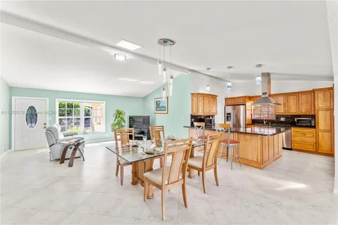a very nice looking dining room with kitchen island furniture and a potted plant