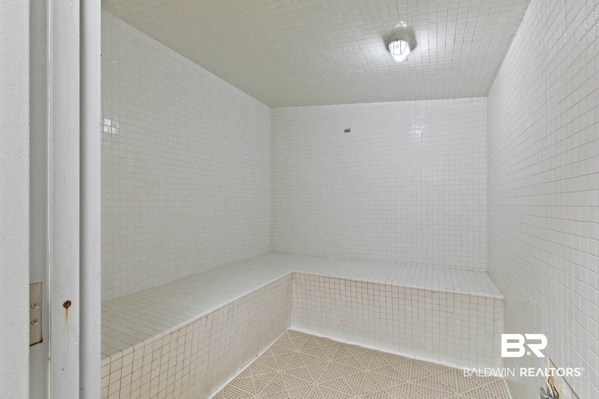 400 Plantation Road, Unit 4501 Gulf Shores, AL 36542 - Photo 22 of 30 White tile interior with integrated bench seating, textured flooring, and a flush-mount overhead light fixture