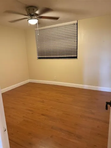 a view of a room with wooden floor and fan