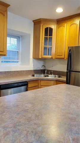 a kitchen with stainless steel appliances granite countertop a sink and a refrigerator