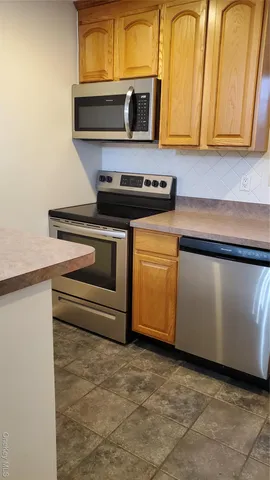 a kitchen with granite countertop cabinets stainless steel appliances and a sink
