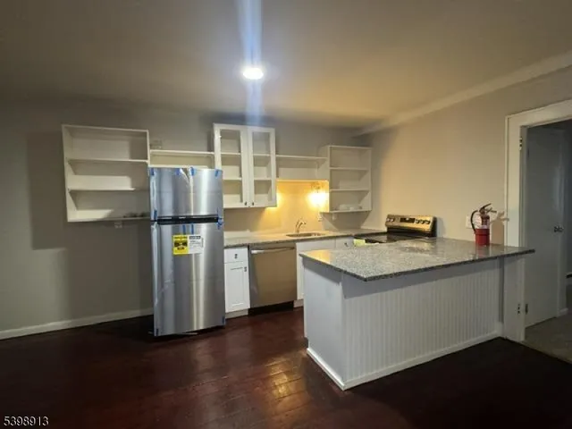 a kitchen with stainless steel appliances granite countertop a sink and a refrigerator