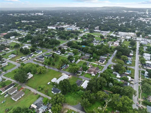 an aerial view of city lake and trees