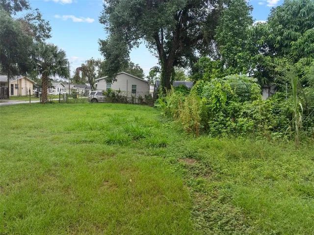 a view of house with yard and trees in the background