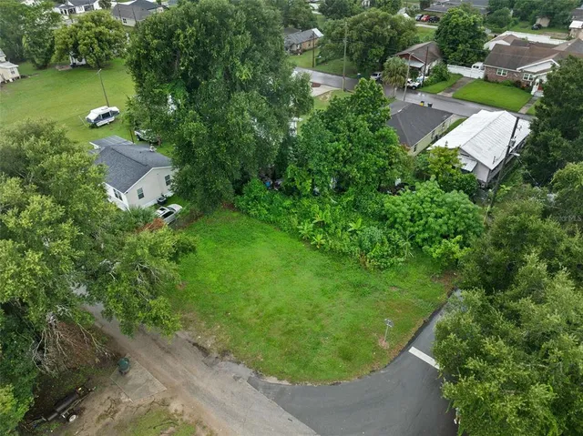 an aerial view of residential house with outdoor space and trees all around