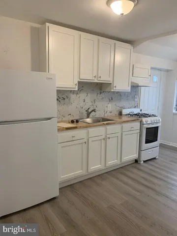 a kitchen with a sink a refrigerator and cabinets