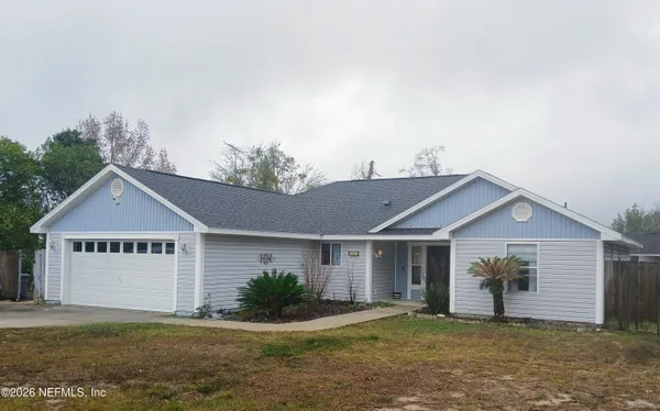 a view of a house with a yard and garage