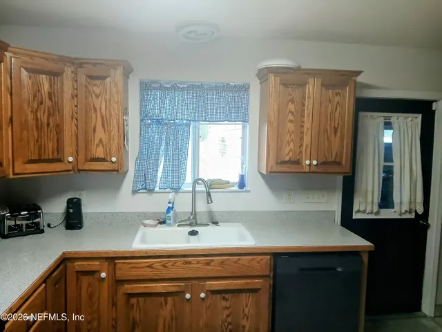 a kitchen with a sink cabinets and a window
