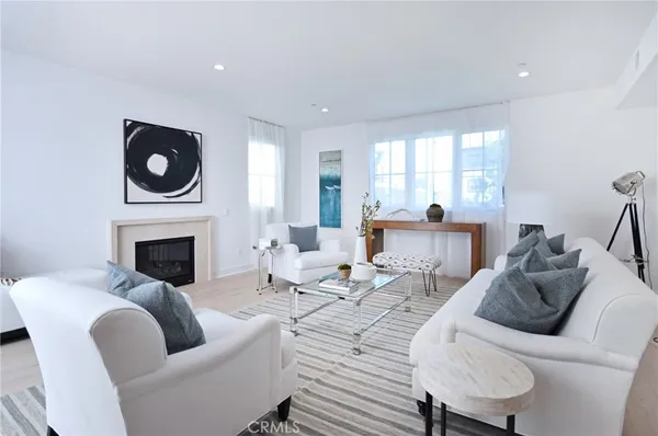 a living room with furniture a fireplace and a floor to ceiling window