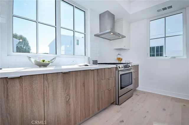a kitchen with a sink a stove cabinets and a window