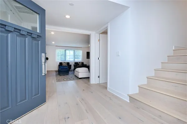 a view of a hallway with wooden floor and furniture