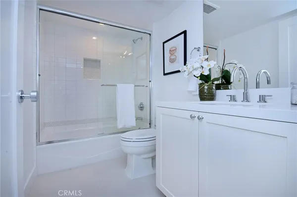 a bathroom with a shower sink vanity and toilet