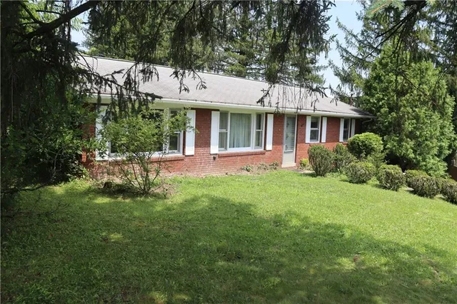 a front view of a house with a garden and plants