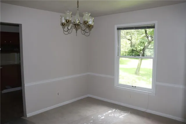 a view of an empty room with wooden floor and windows