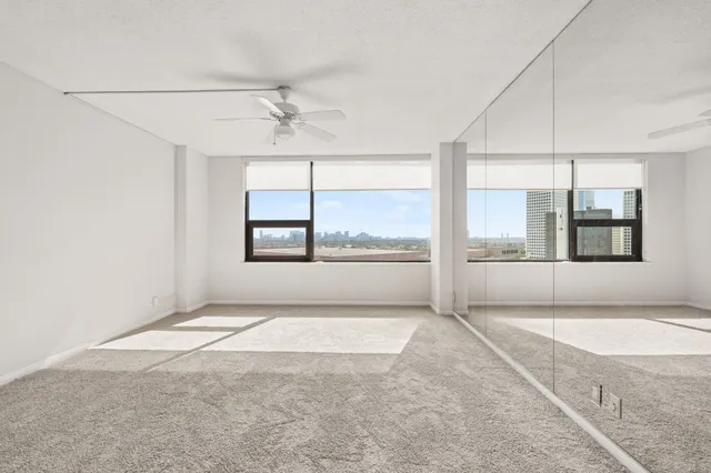 an empty room with large windows and chandelier