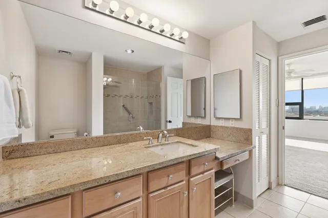 a bathroom with a granite countertop sink and a mirror