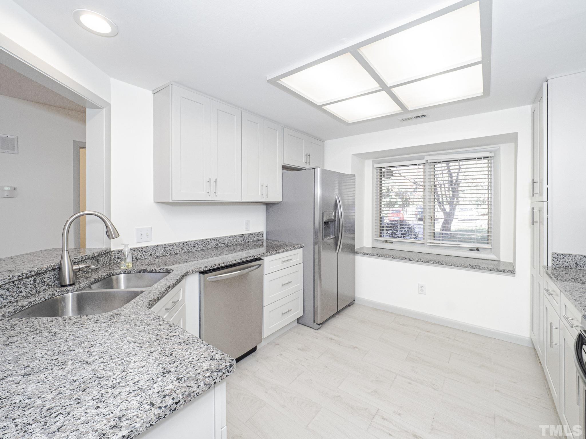 4349 Sunscape Lane Raleigh, NC 27613 - Photo 12 of 28 a kitchen with stainless steel appliances granite countertop a sink stove and refrigerator