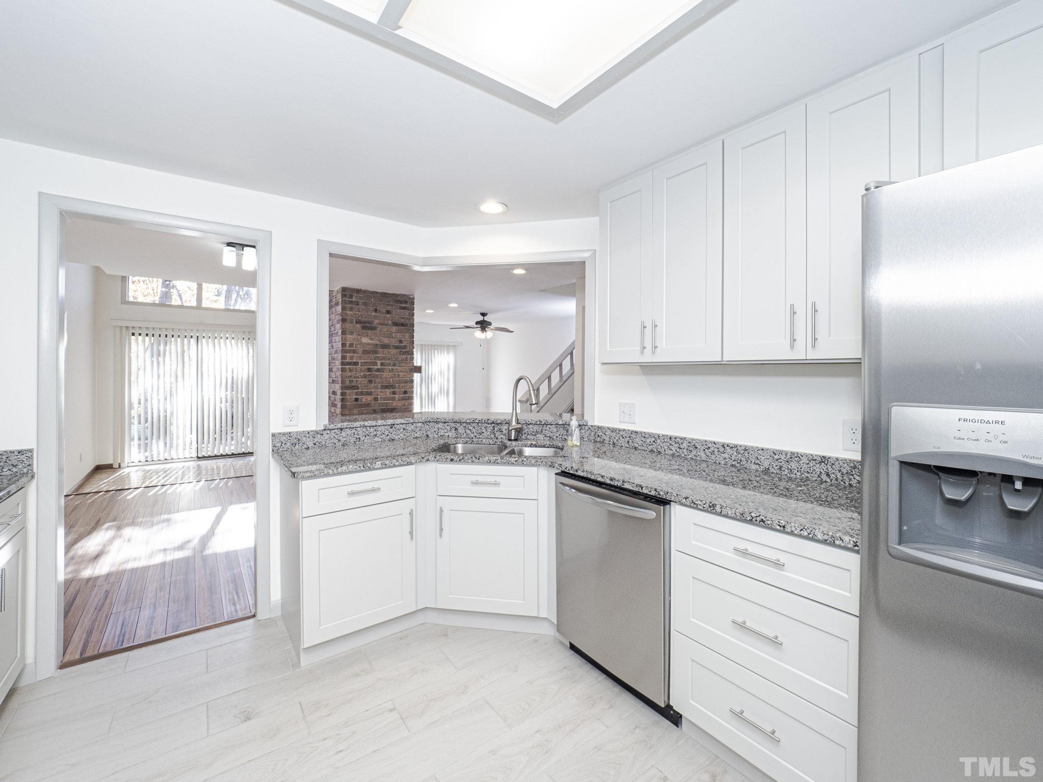 4349 Sunscape Lane Raleigh, NC 27613 - Photo 13 of 28 a kitchen with granite countertop stainless steel appliances and white cabinets