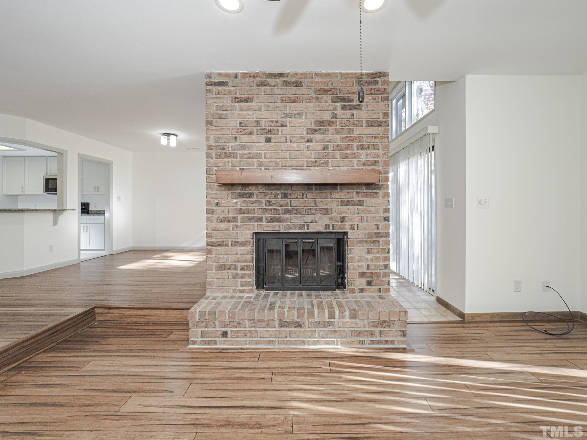 4349 Sunscape Lane Raleigh, NC 27613 - Photo 16 of 28 a living room with a fireplace and wooden floor