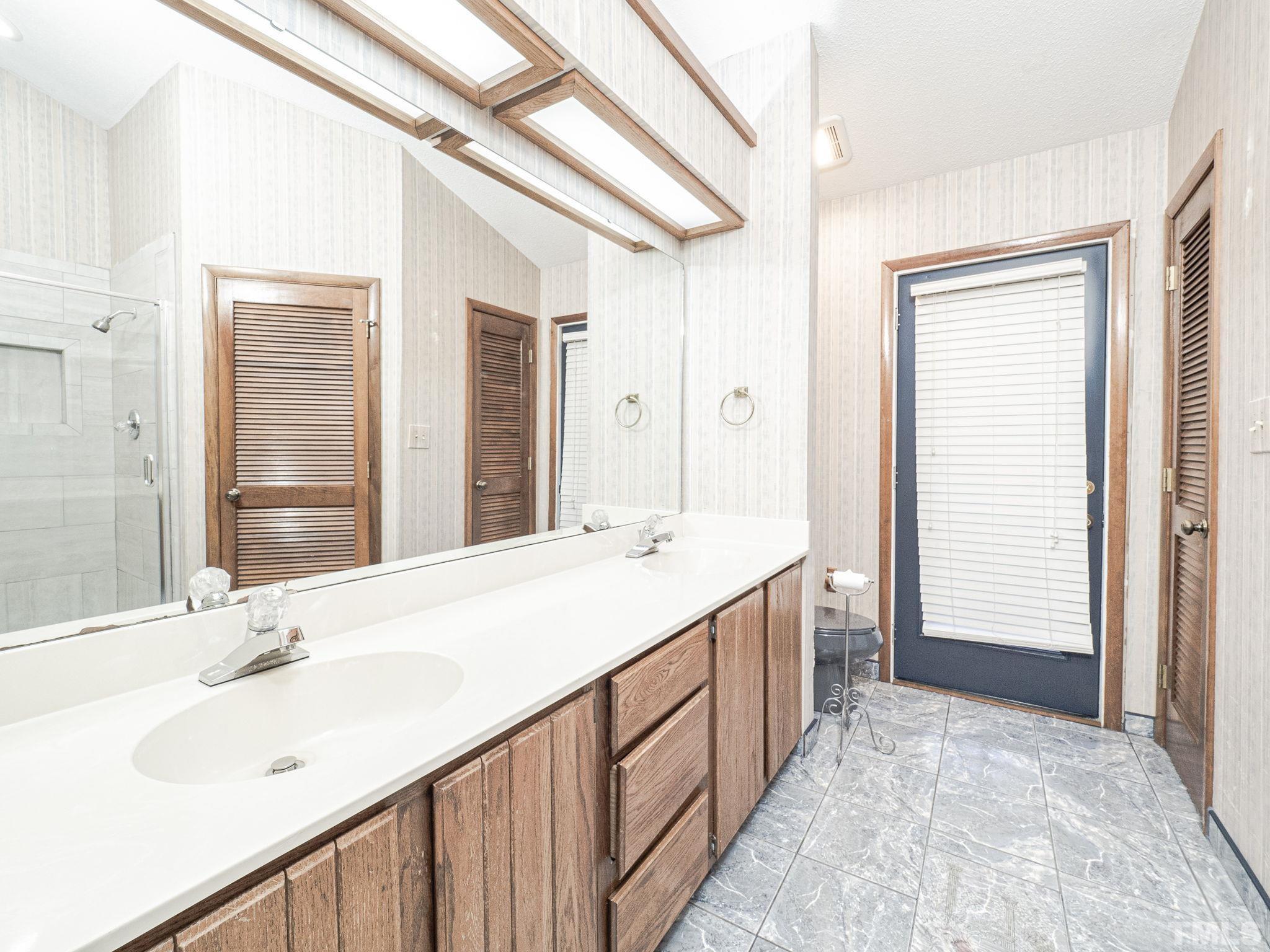 4349 Sunscape Lane Raleigh, NC 27613 - Photo 24 of 28 a bathroom with a sink double vanity shower and a mirror