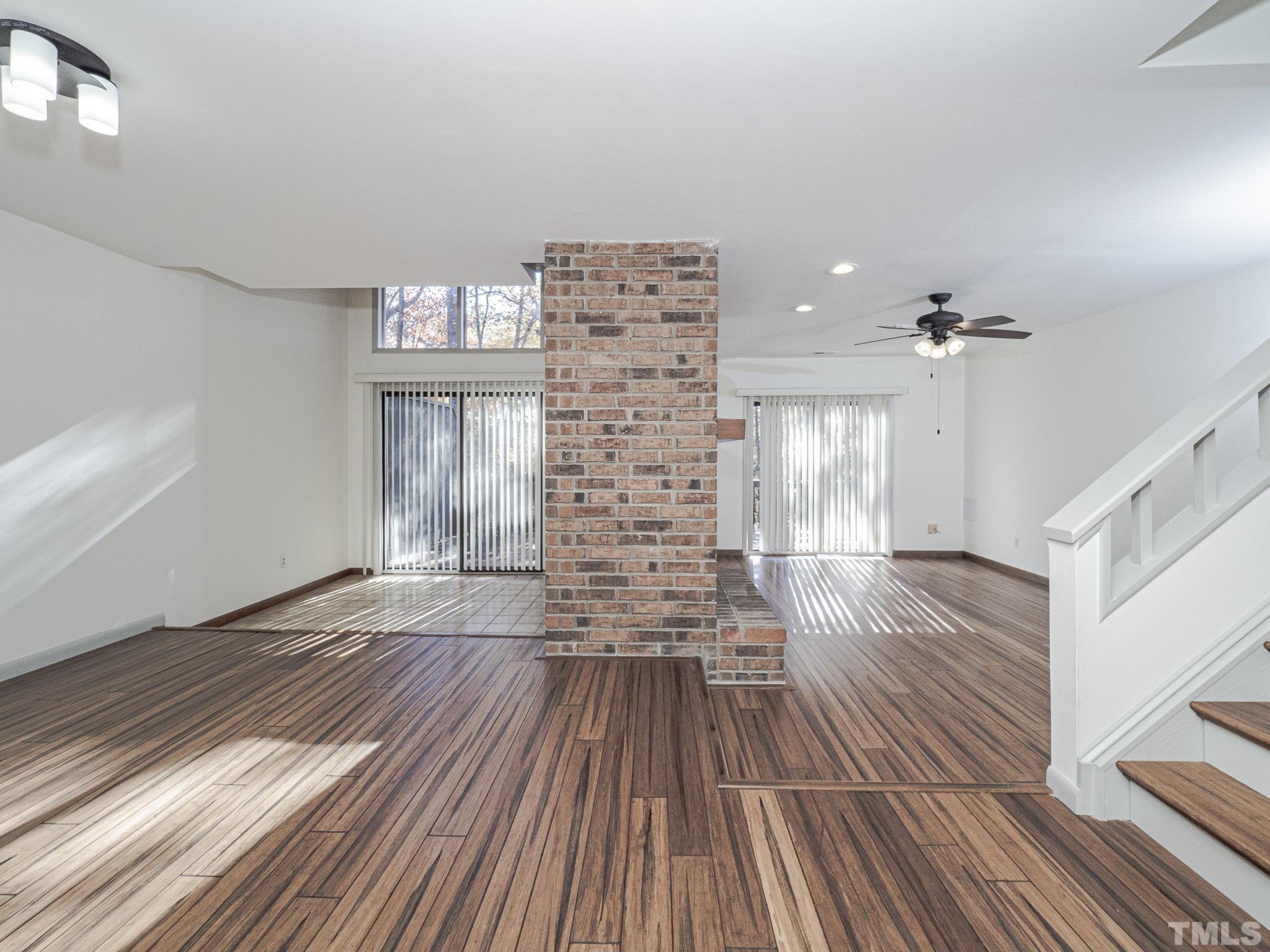 4349 Sunscape Lane Raleigh, NC 27613 - Photo 8 of 28 a view of a room with wooden floor staircase and a kitchen