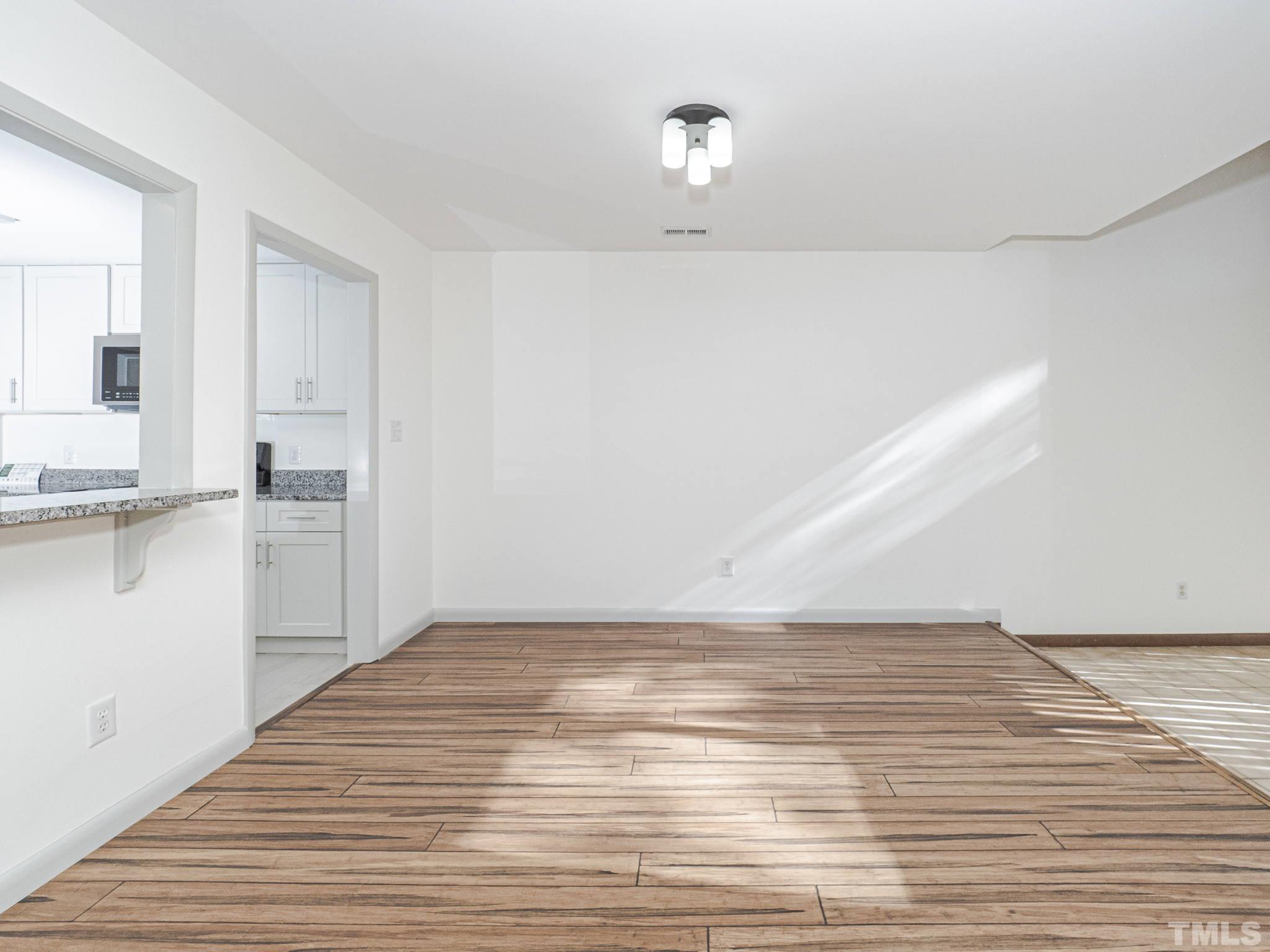 4349 Sunscape Lane Raleigh, NC 27613 - Photo 9 of 28 a view of empty room with wooden floor