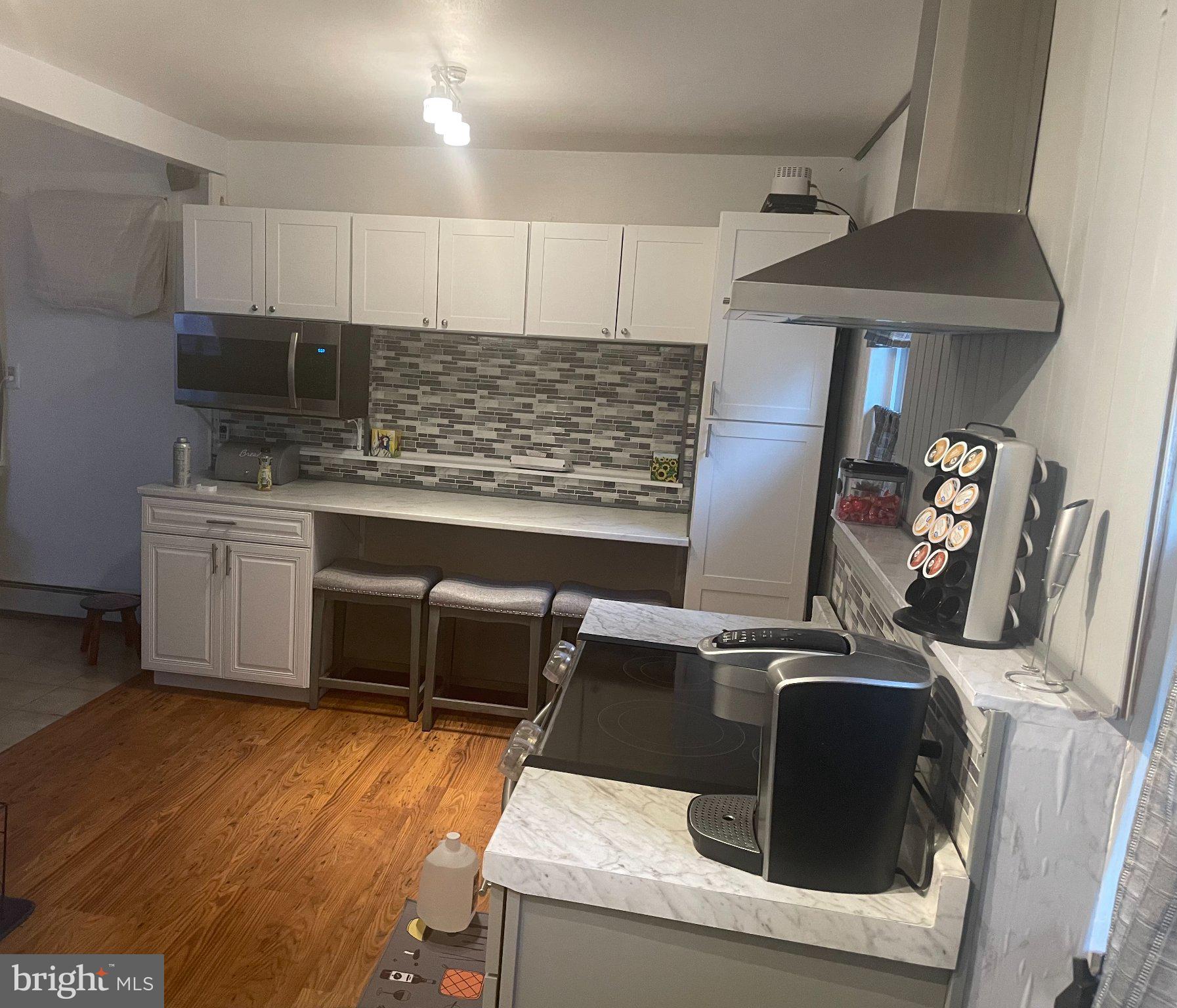 15 Rieve Avenue New Castle, DE 19720 - Photo 4 of 4 a kitchen with kitchen island granite countertop a stove top oven a sink a counter space and cabinets