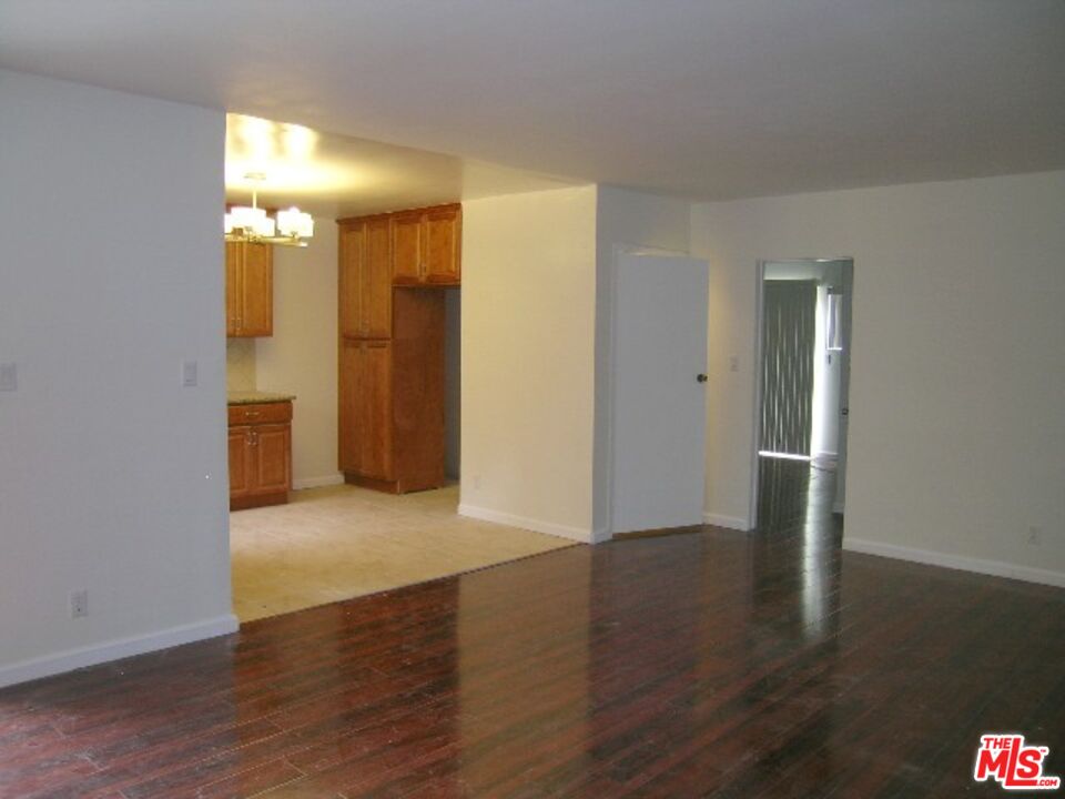 an empty room with wooden floor and a bathroom