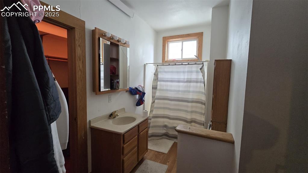 414 Seventh Street Hugo, CO 80821 - Photo 11 of 30 a bathroom with a sink a mirror and shower