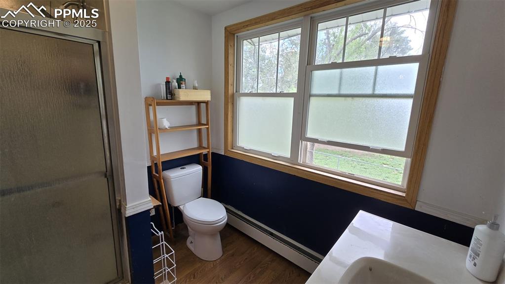 414 Seventh Street Hugo, CO 80821 - Photo 14 of 30 a bathroom with a toilet a sink and a window