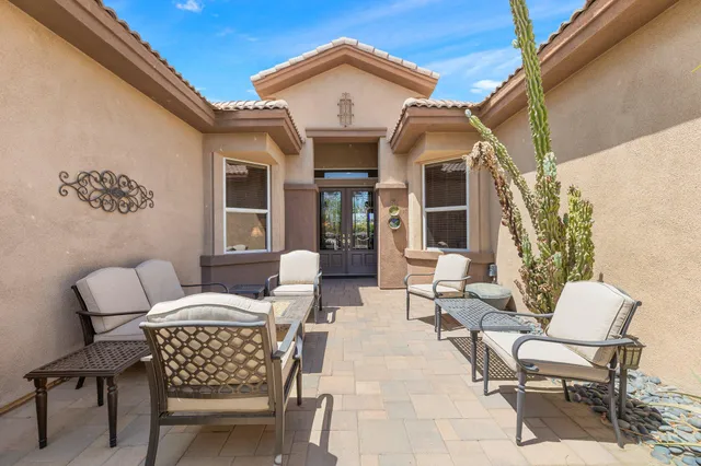 a view of a patio with couches table and chairs and potted plants