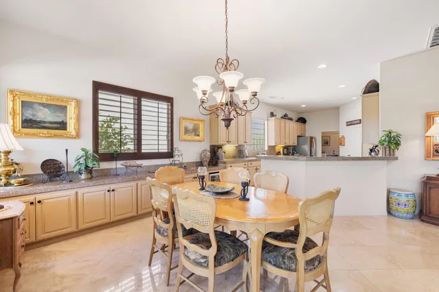 a dining room filled chandelier and kitchen view