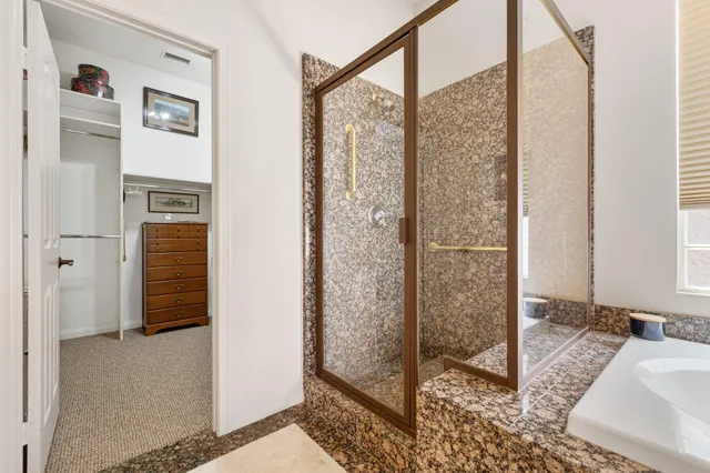 a bathroom with a granite countertop shower a mirror and a sink