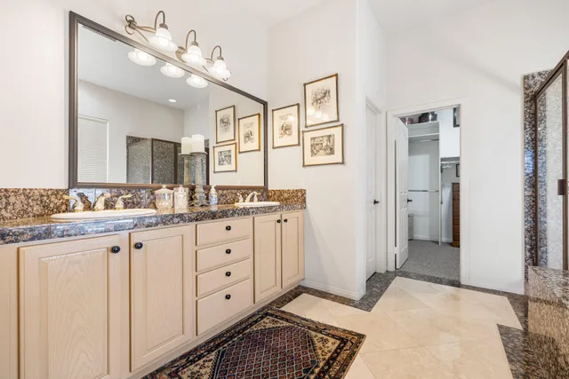 a spacious bathroom with a granite countertop sink a mirror and a shower